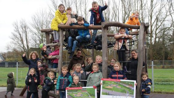Kinderen in een speeltoestel met bouwtekeningen in hun hand van de nieuwe speeltuin in Zoutkamp.
