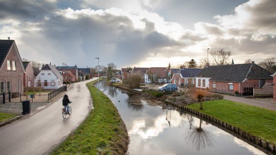 Vrouw fietst langs het kanaal in Woltersum.