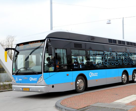 Blauwe waterstofbus van Qbuzz die richting Delfzijl rijdt.