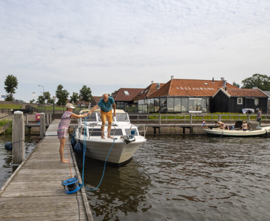 Decoratieve afbeelding van twee mensen die bootje gaan varen in Zoutkamp
