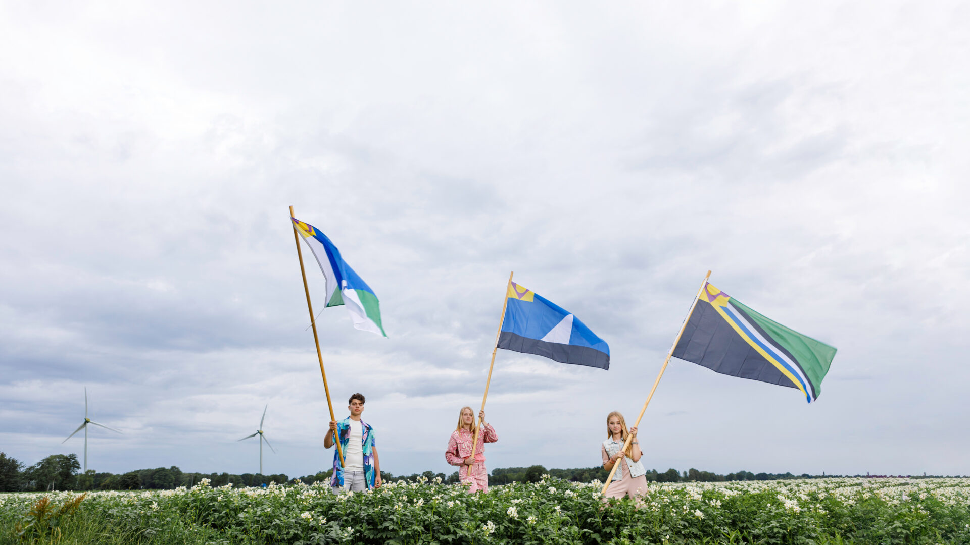 Jongeren zwaaien met vlaggen van de Veenkoloniën.